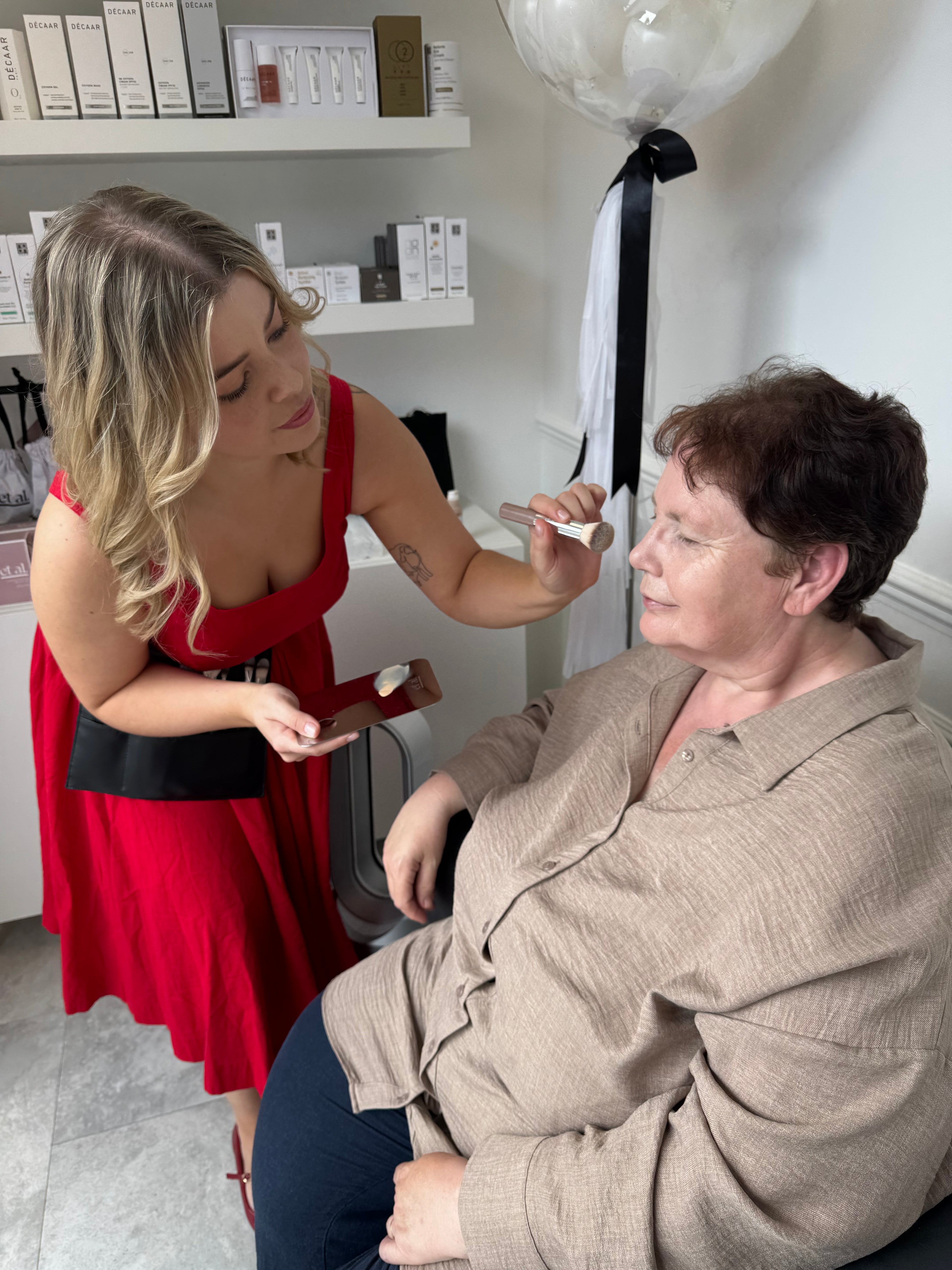 Clarissa putting makeup on a client